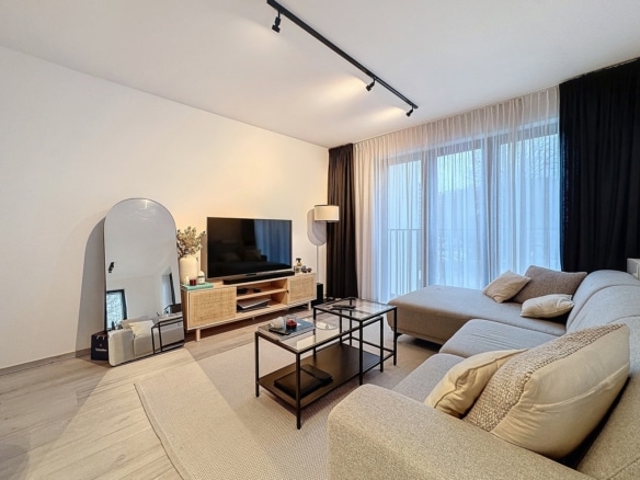 Salon moderne lumineux dappartement avec canapé dangle et grandes fenêtres   appartement 1 chambre  woluwe saint lambert