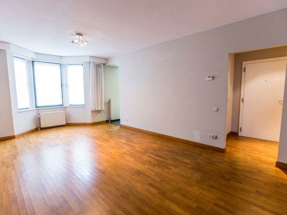 Salon lumineux dappartement vide avec parquet grandes fenêtres et radiateurs   appartement 1 chambre  bruxelles