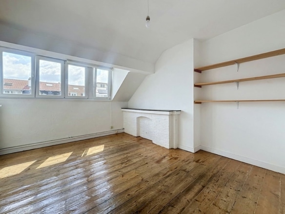 Licht appartement op de zolderverdieping met oud parket, grote ramen en een open haard   appartement met 1 slaapkamer  Saint Gilles
