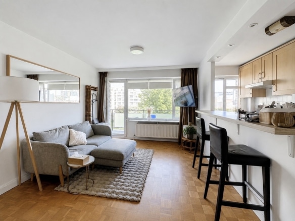 Lichte woonkamer met open keuken en balkon in een modern appartement   appartement met 1 slaapkamer   Evere
