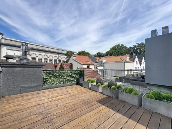 Terrasse rooftop en bois avec jardinières et vue sur toits urbains   appartement 1 chambre  bruxelles