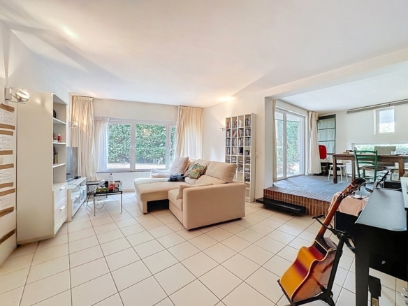 Salon lumineux dappartement avec salle à manger surélevée et grandes baies vitrées   appartement 1 chambre  uccle