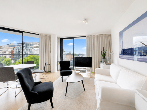 Salon lumineux dun appartement moderne avec grandes baies vitrées et mobilier design   appartement 2 chambres  ixelles