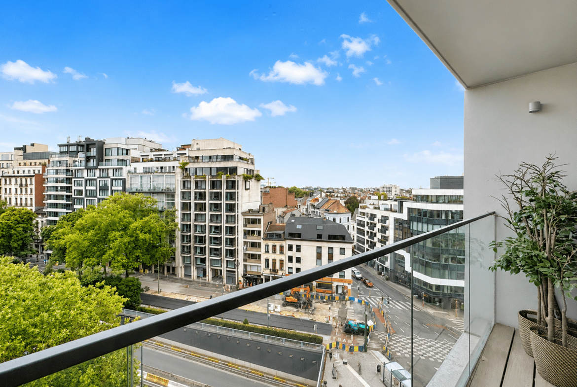 Terrasse d’appartement moderne avec vue urbaine et balcon vitré.