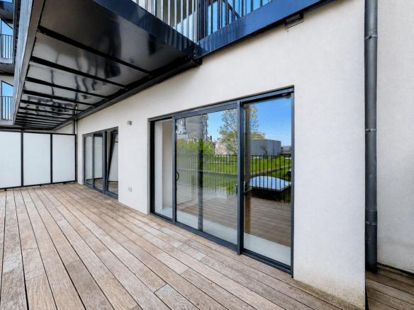 Terrasse en bois dun appartement moderne avec baies vitrées et balcon couvert   appartement 1 chambre  bruxelles