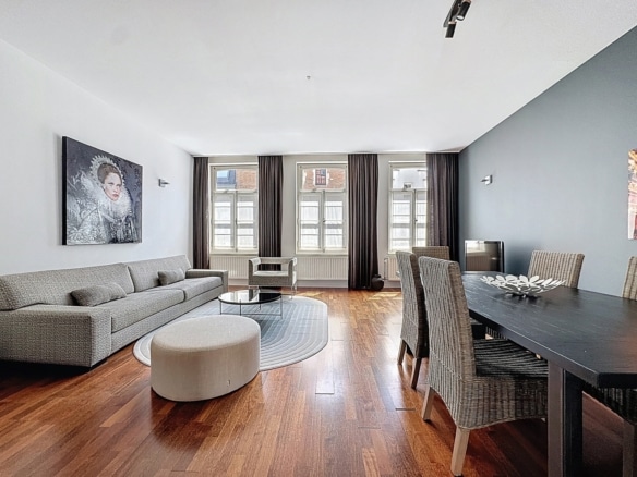 Salon et salle à manger modernes dun appartement lumineux avec parquet et grandes fenêtres   appartement 2 chambres  bruxelles