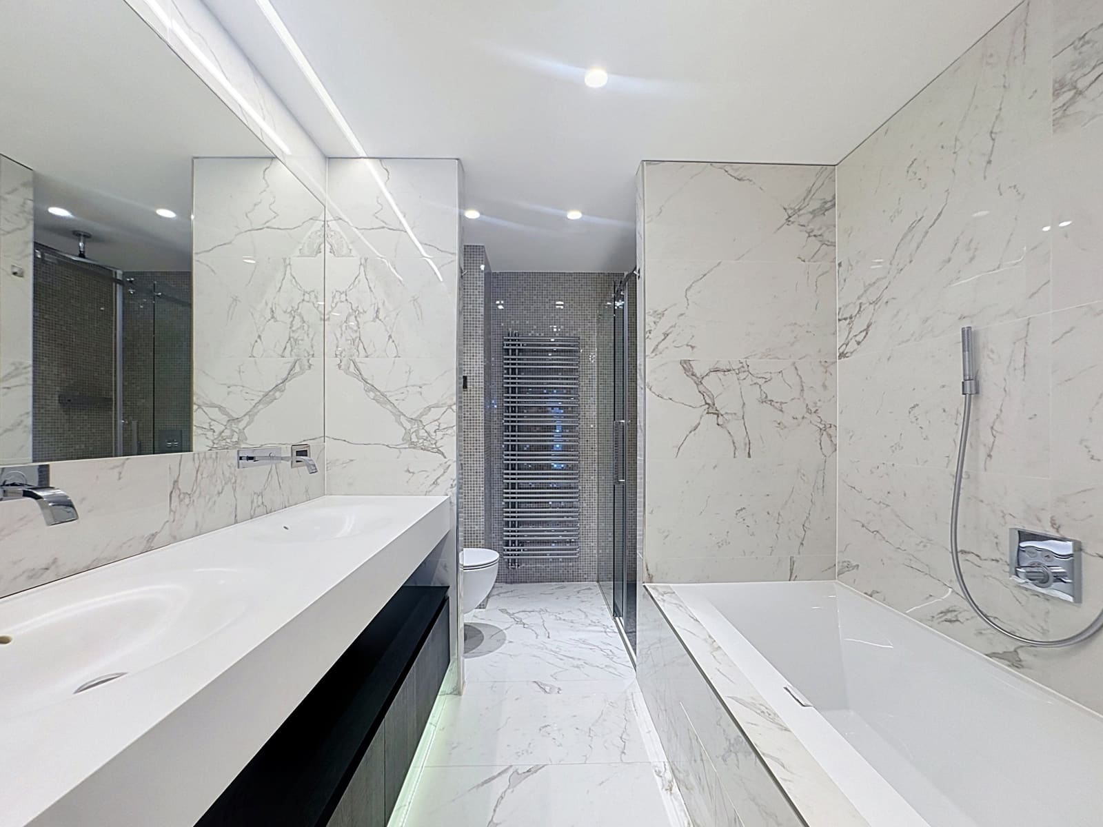 Salle De Bains Marbrée Avec Double Vasque – You Real Estate Agency Salle de bains moderne en marbre avec double vasque et baignoire d’appartement.