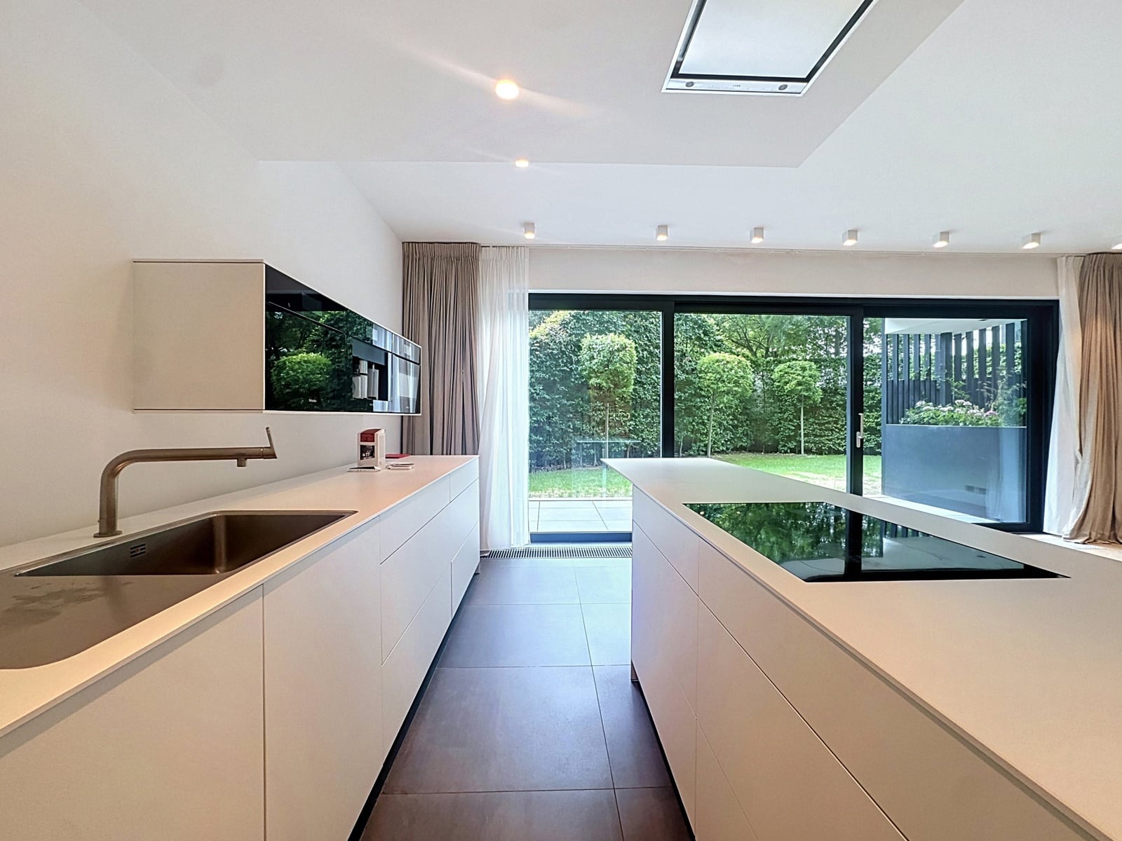 Cuisine Moderne avec Vue sur Jardin – You Real Estate Agency Cuisine moderne de maison avec îlot central et vue sur jardin.