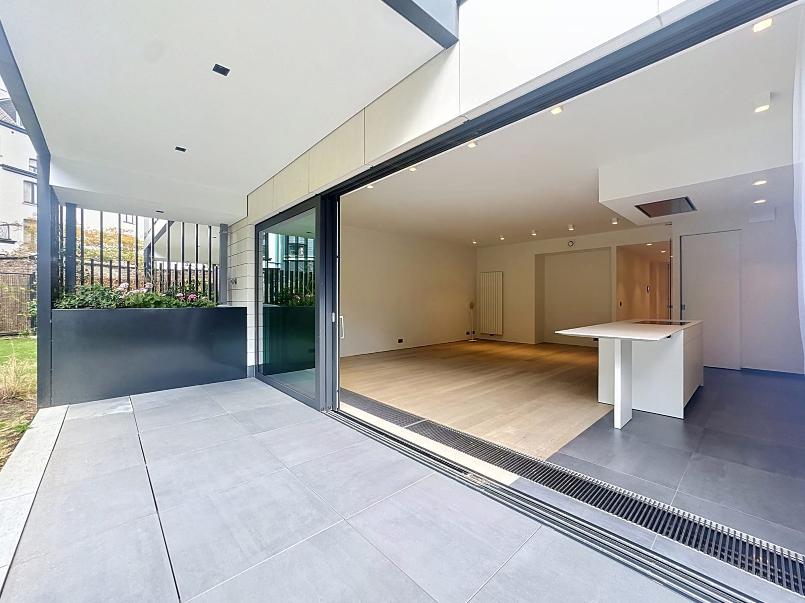Séjour Ouvert avec Terrasse – You Real Estate Agency Maison moderne avec terrasse, cuisine ouverte et salon lumineux.