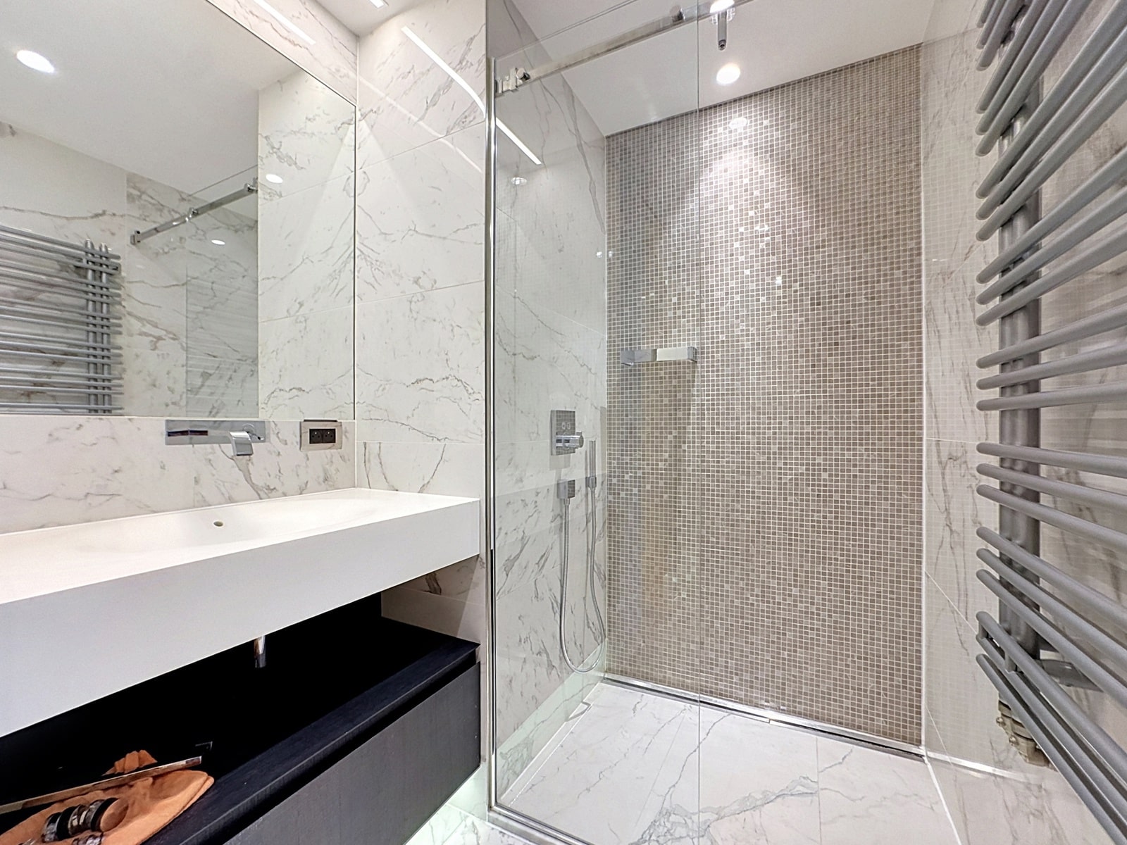Salle de Bain avec Douche Vitrée – You Real Estate Agency Salle de bain moderne en marbre avec douche vitrée pour appartement.