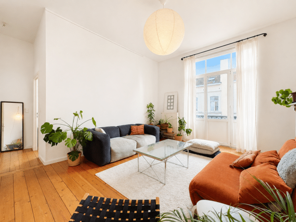 Salon lumineux dappartement avec hauts plafonds parquet bois et canapé terracotta   appartement 1 chambre  forest