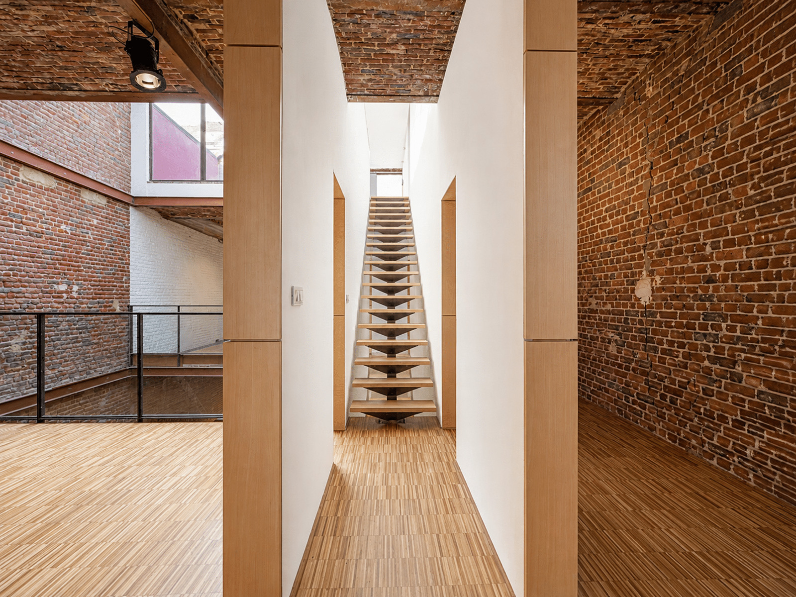 Loft Avec Escalier Flottant – You Real Estate Agency Appartement loft avec escalier flottant, murs en briques apparentes et parquet bois.