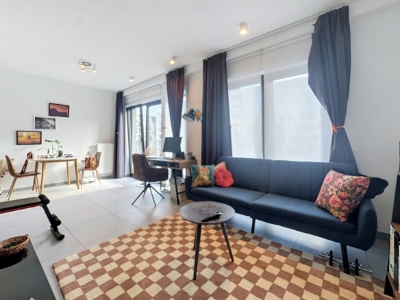 Salon lumineux dappartement avec coin bureau salle à manger et grandes fenêtres   appartement 1 chambre  ixelles