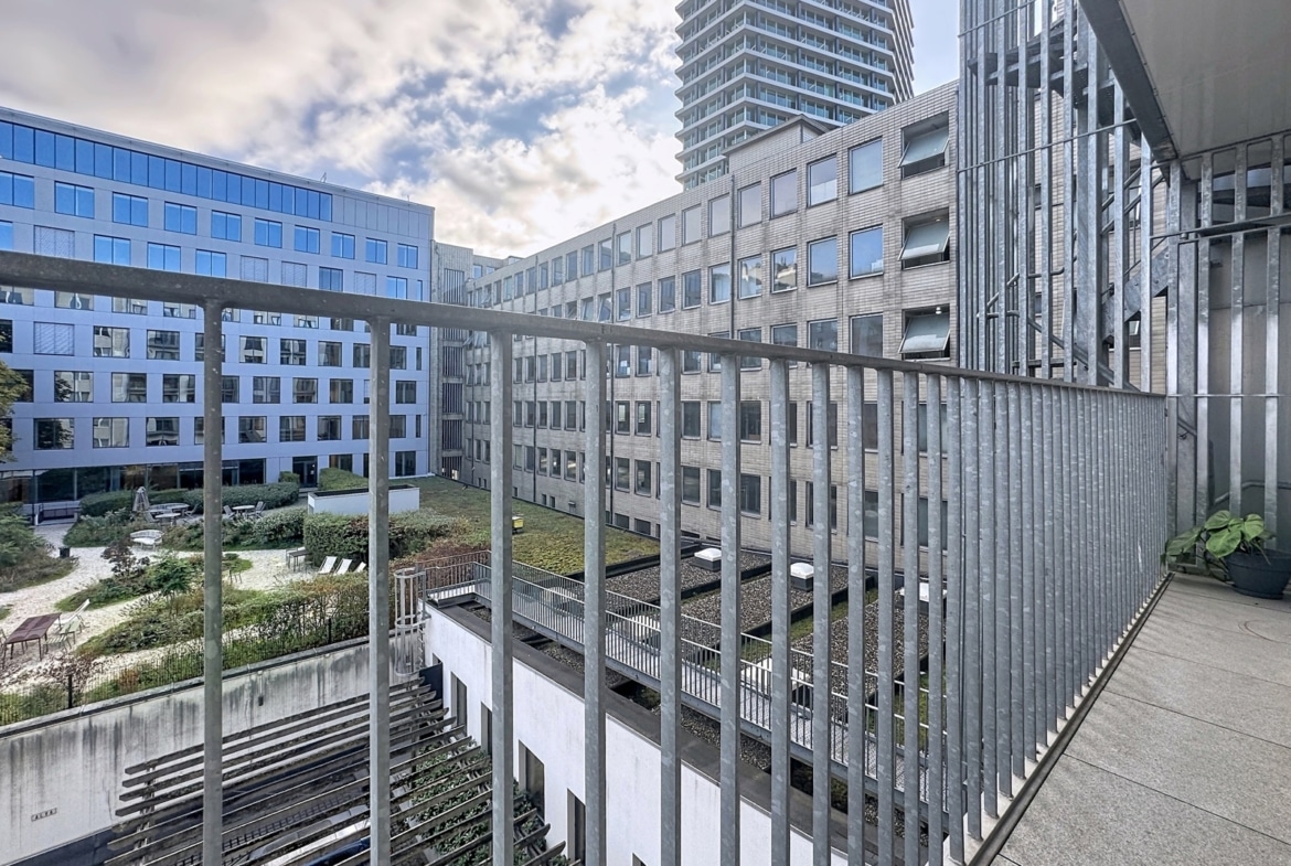 View from an apartment terrace of a modern inner courtyard and residential buildings.