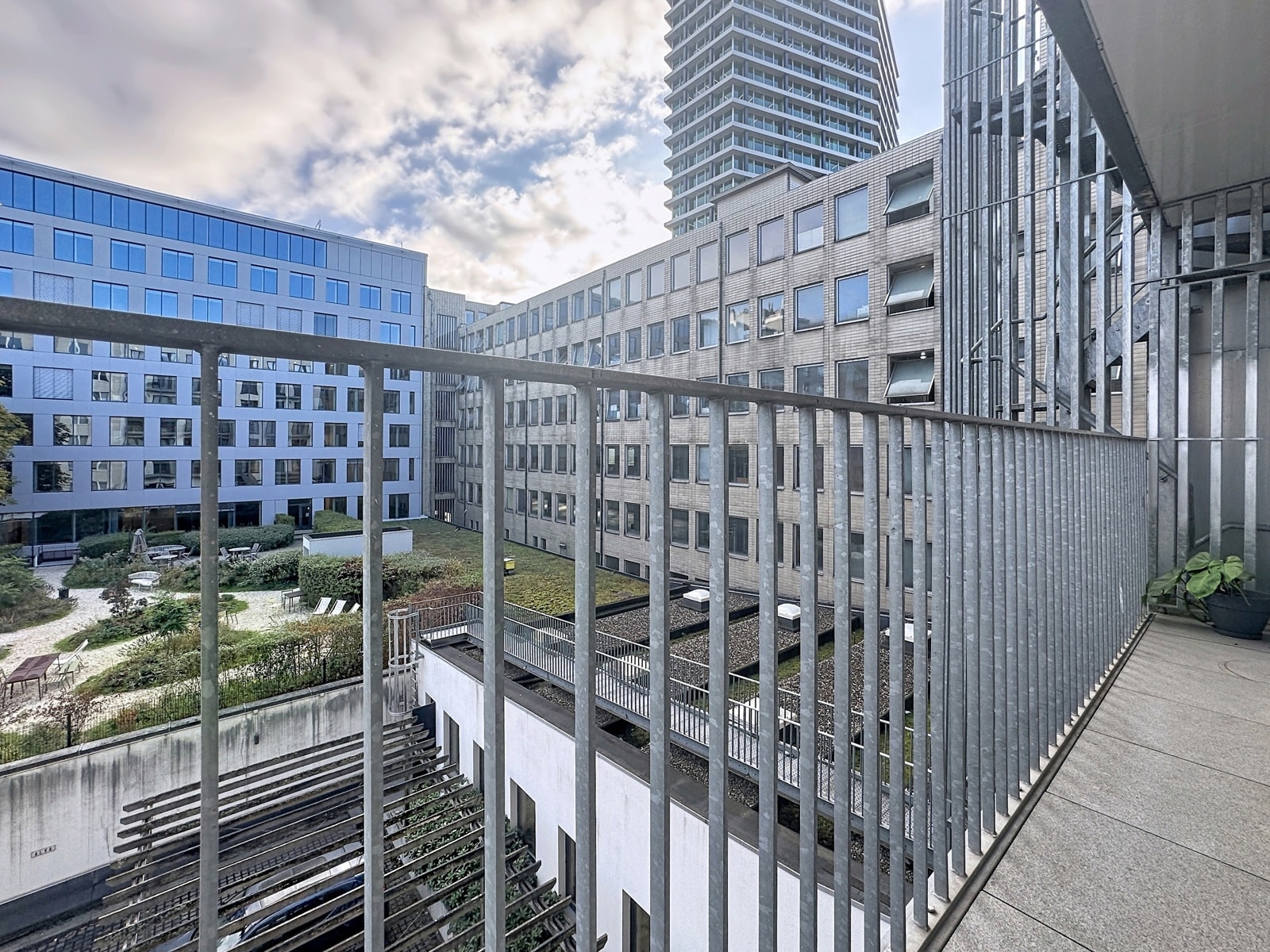 View of a Modern Inner Courtyard – You Real Estate Agency View from an apartment terrace of a modern inner courtyard and residential buildings.