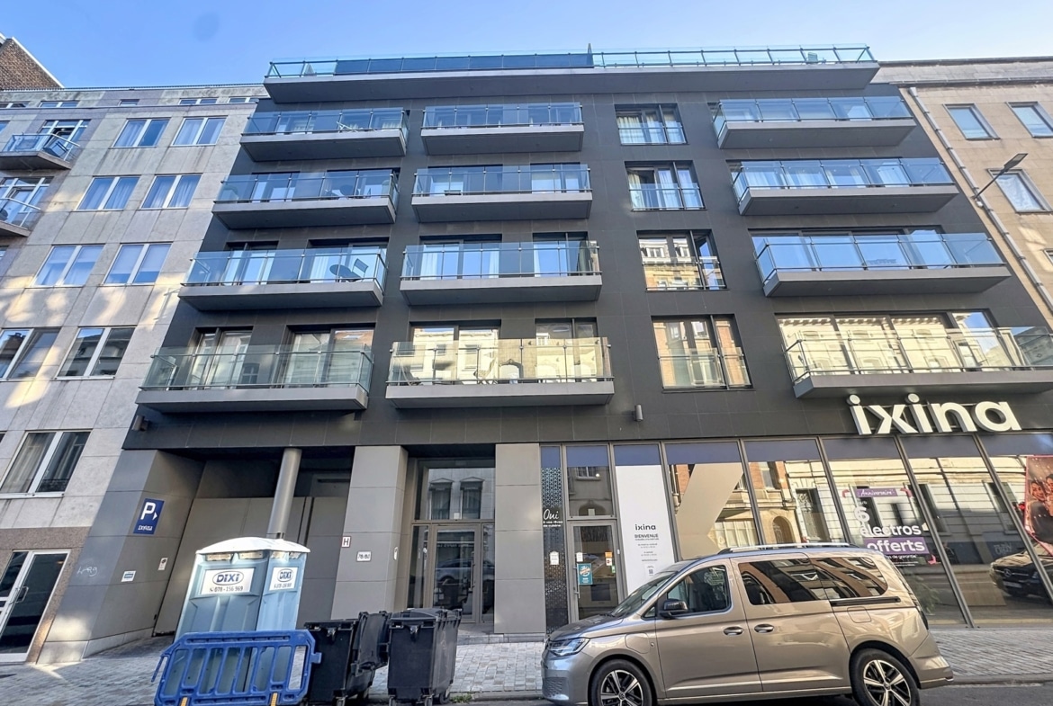 A modern building with apartments and balconies, and a store on the ground floor.