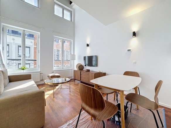 Salon lumineux avec coin salle à manger et hauts plafonds dans appartement moderne   appartement 1 chambre  bruxelles