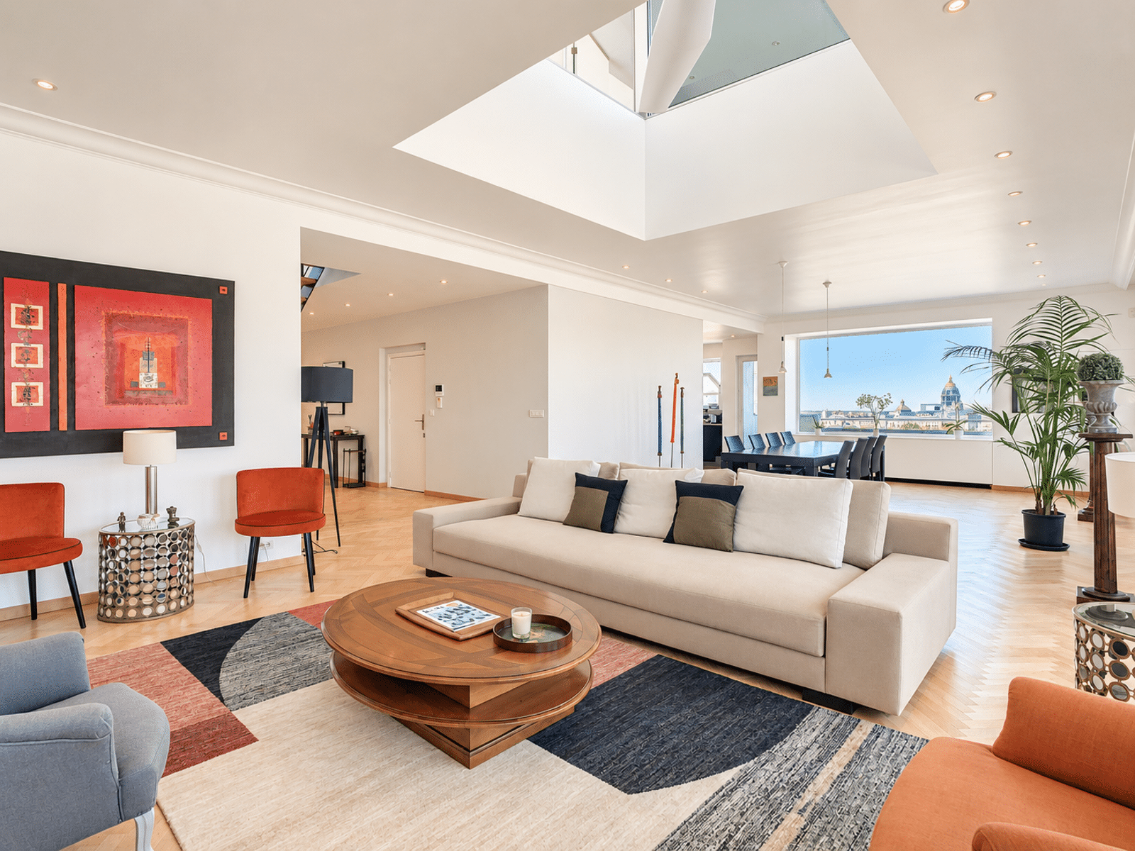 Bright Living Room with Skylight – You Real Estate Agency Bright living room in a contemporary apartment with a skylight, hardwood floors, and a city view.