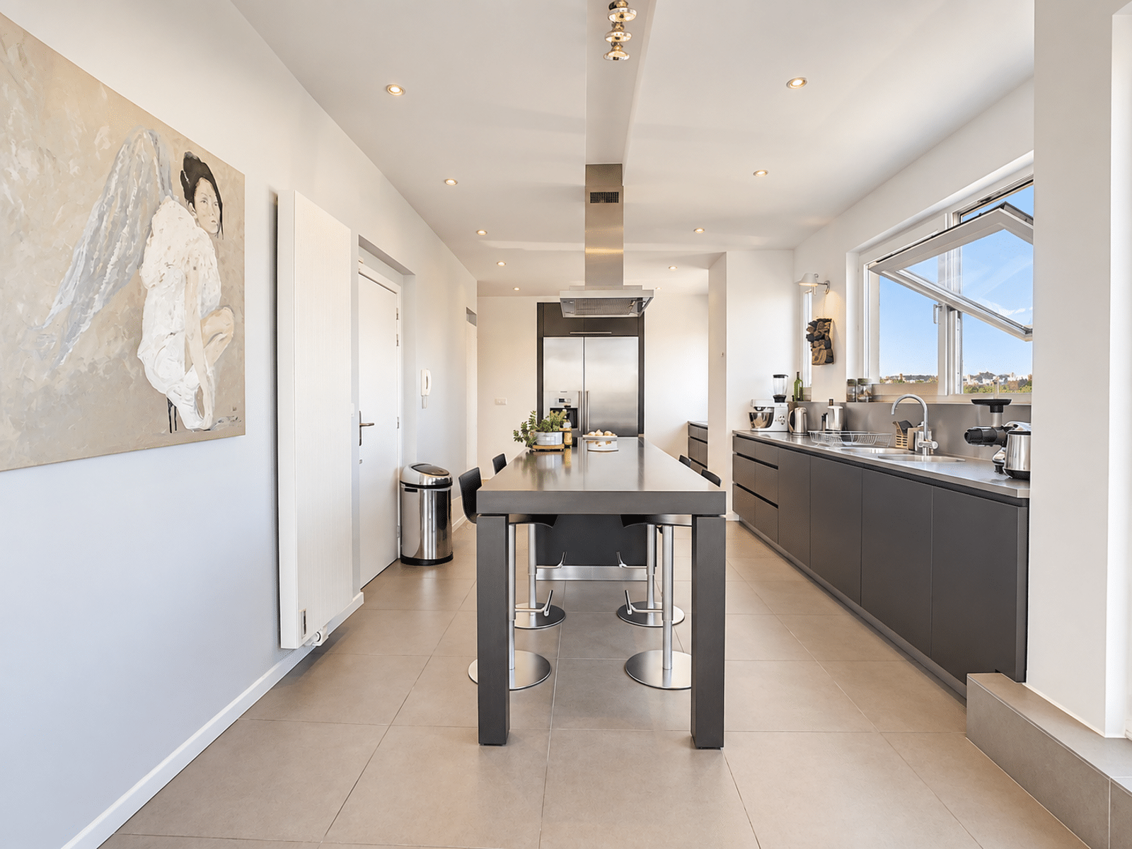 Bright Modern Kitchen With Island - You Real Estate Agency A bright, modern kitchen with a central island and built-in appliances in an apartment.
