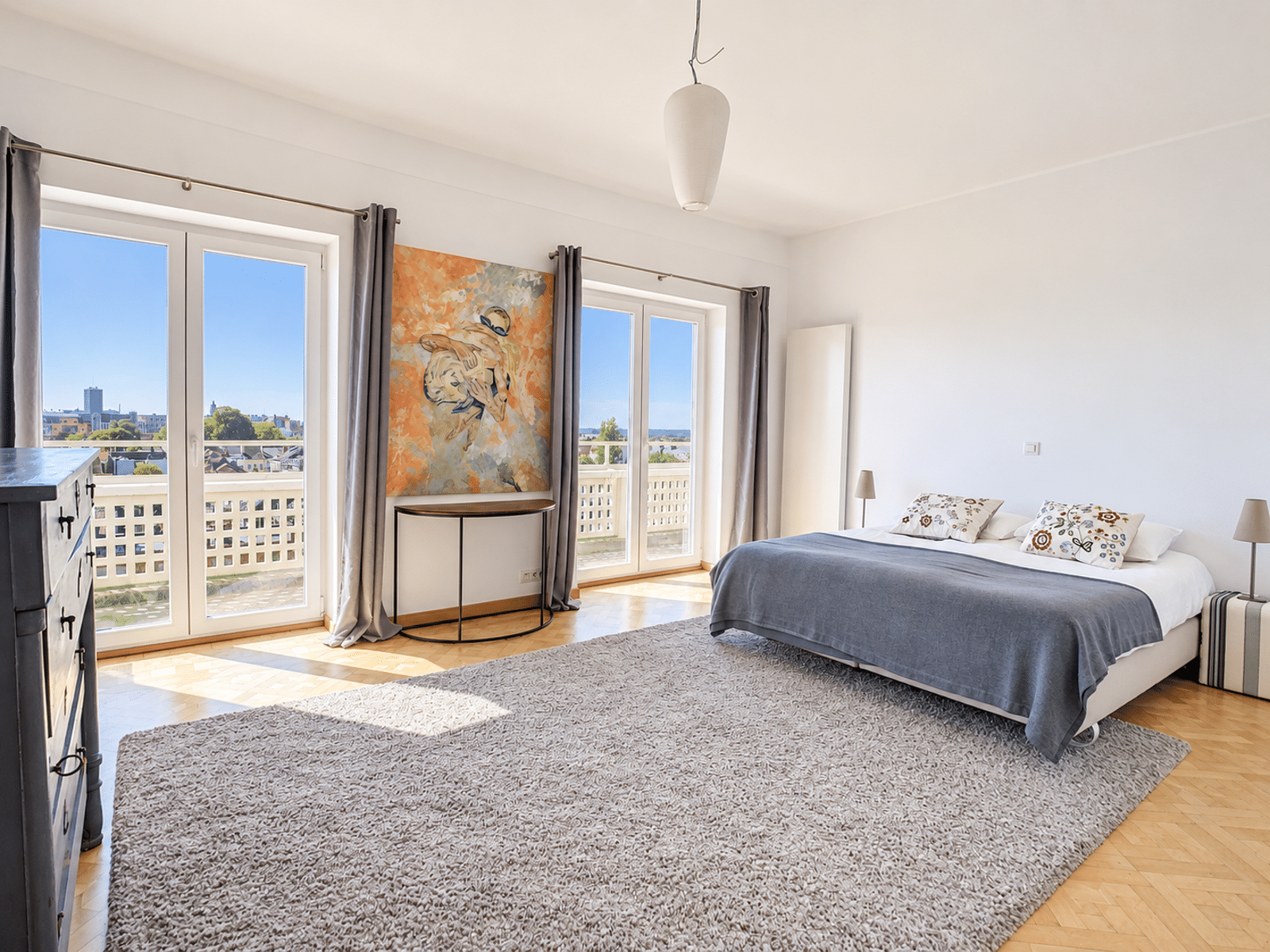 Bright Room with Balcony – You Real Estate Agency A bright apartment bedroom with a balcony, hardwood floors, and modern decor.