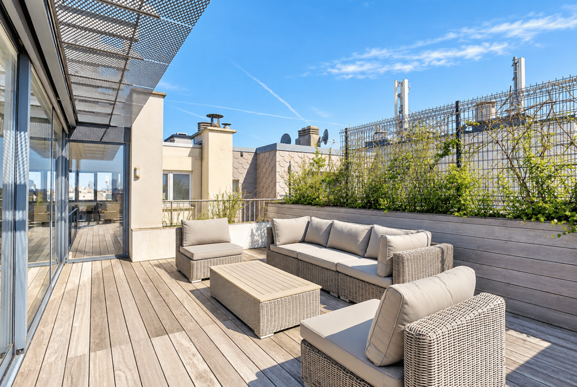Modern rooftop terrace with an outdoor lounge area and city views.