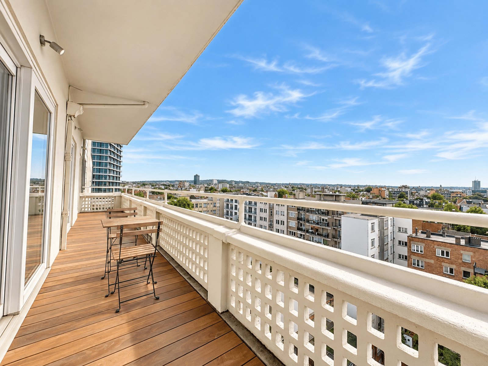 Terrace with City View – You Real Estate Agency Apartment terrace with hardwood floors and a panoramic view of the city.