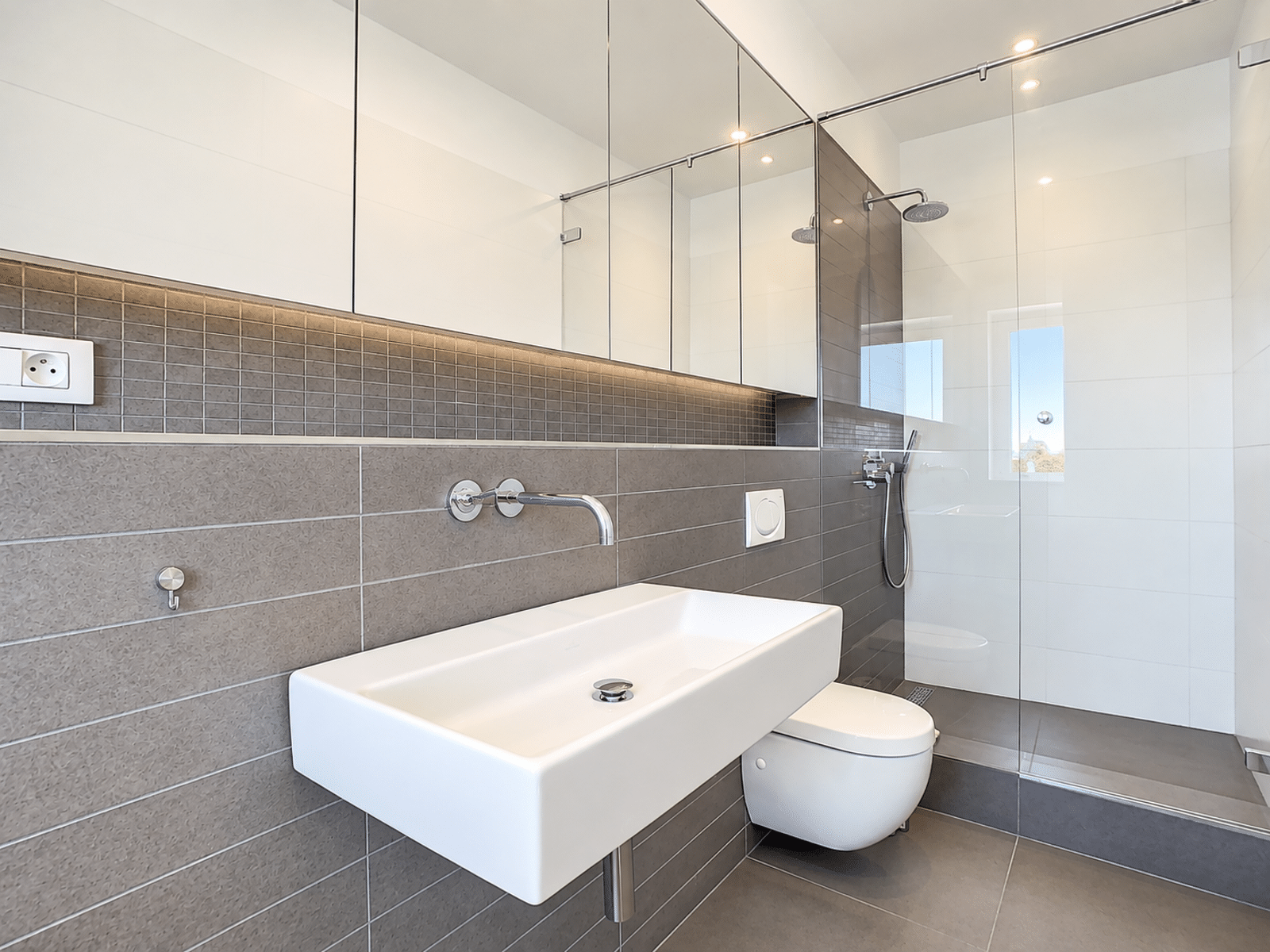 Bathroom with Italian shower - You Real Estate Agency Modern bathroom with a walk-in shower and sink in an apartment.