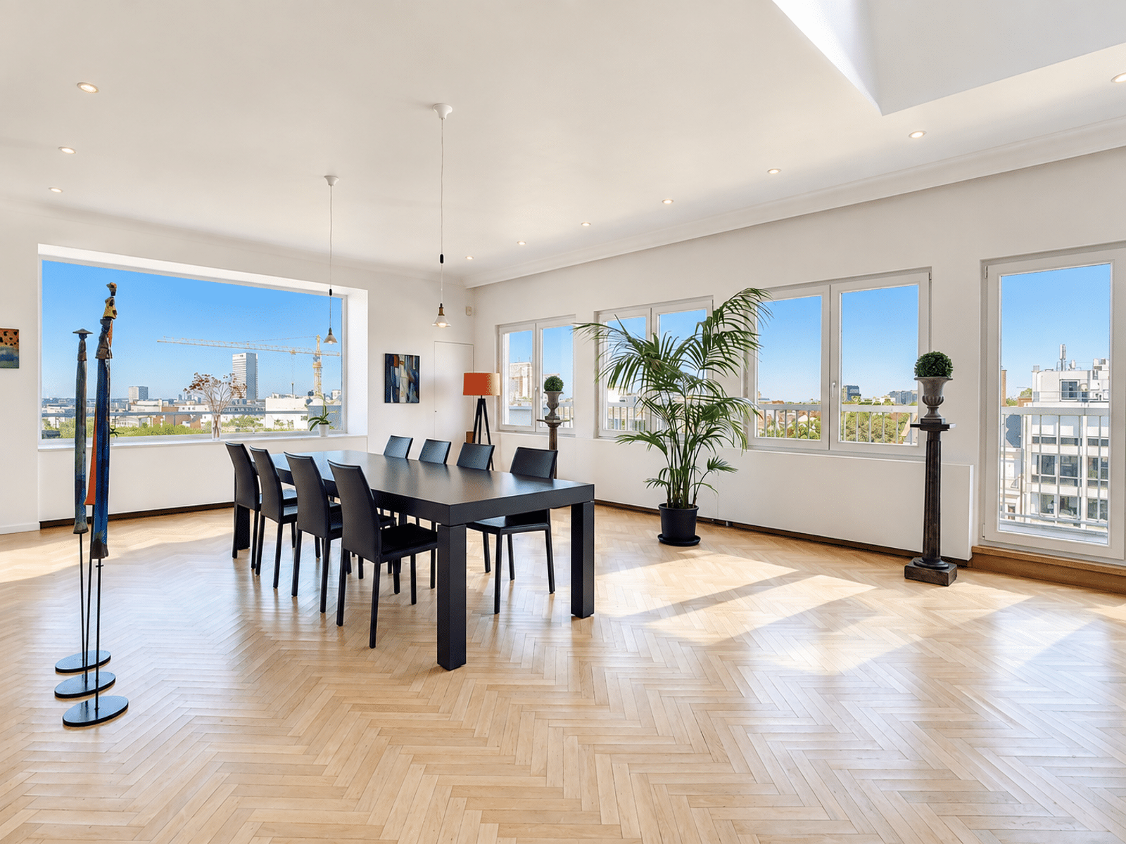 Bright Modern Dining Room - You Real Estate Agency A bright dining room in a modern apartment with hardwood floors, large windows, and a city view.