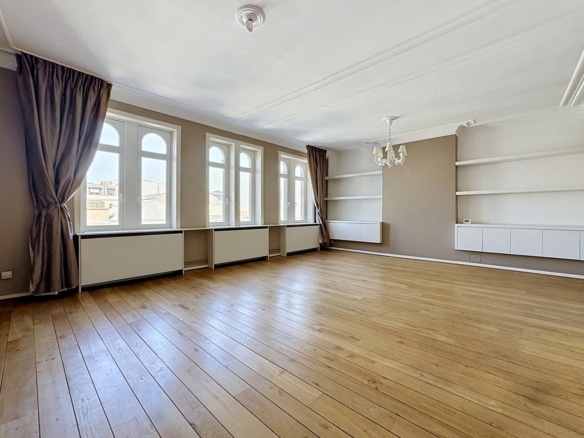 Grote, lichte woonkamer in een appartement met parketvloer, boogramen en inbouwkasten   appartement met 1 slaapkamer  Brussel