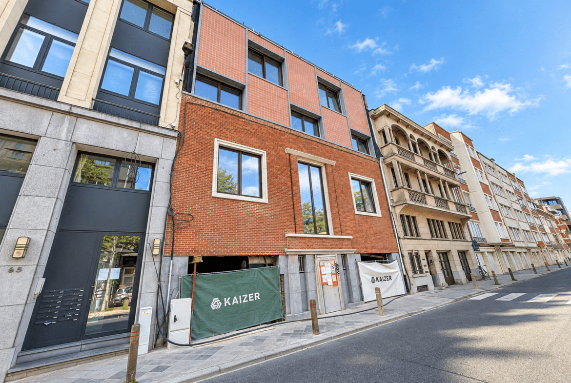 Gevel van een gerenoveerd woongebouw met appartementen aan een rustige straat in de stad.