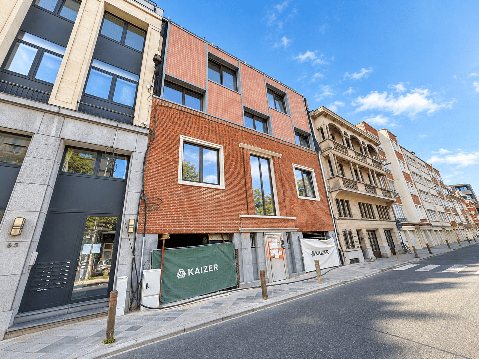 Gerenoveerde woninggevel – You Real Estate Agency Gevel van een gerenoveerd woongebouw met appartementen aan een rustige straat in de stad.