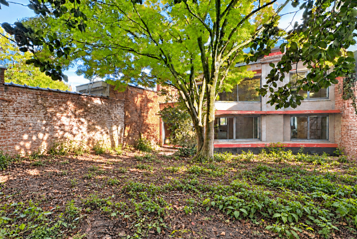 Een appartement met een binnenplaats met bomen en een schaduwrijke tuin.