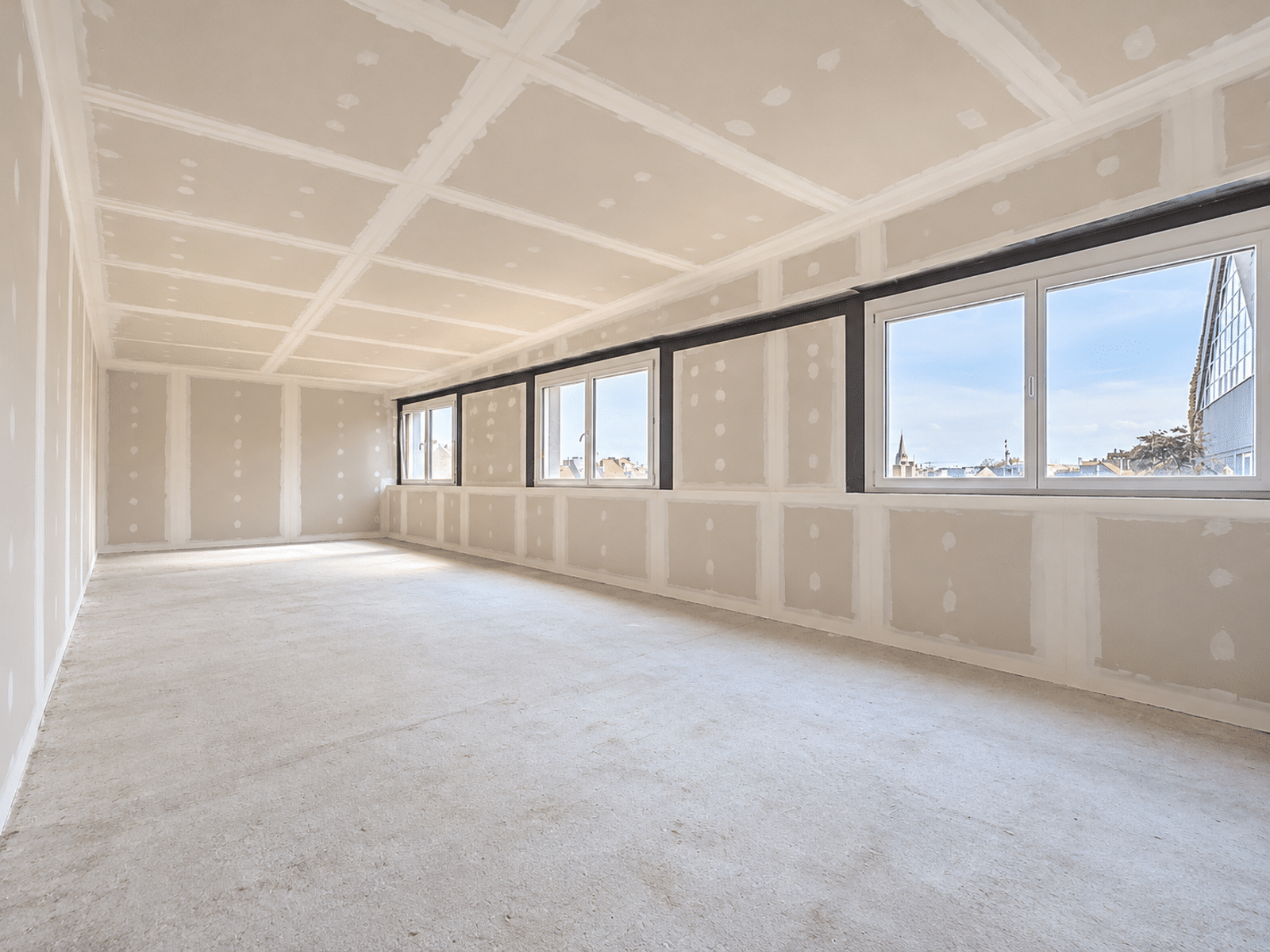 Grote, lichte ruimte in renovatie – You Real Estate Agency Groot appartement in renovatie met een ruime, lichte woonkamer en panoramische ramen.