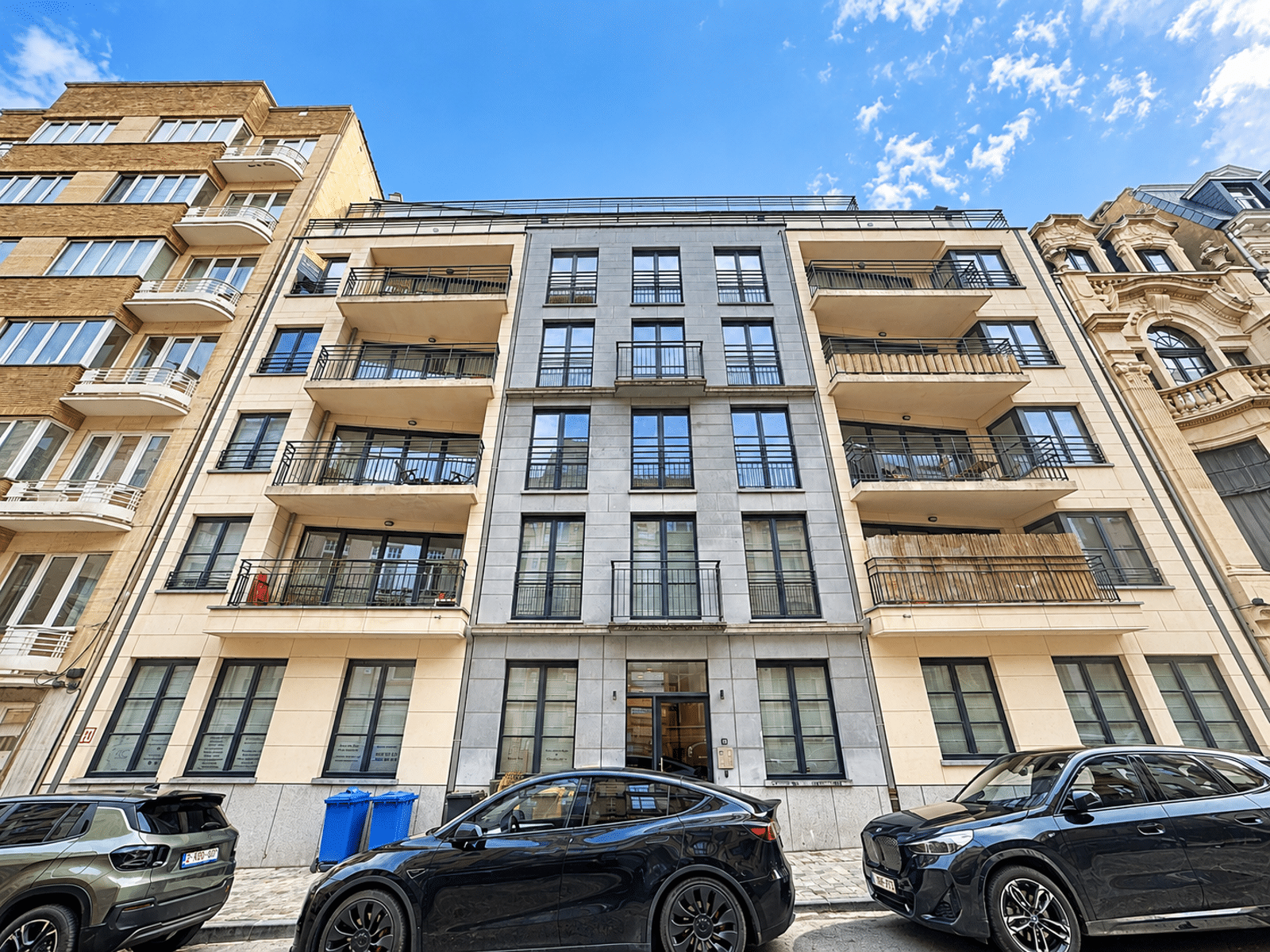 Moderne gevel met balkons – You Real Estate Agency Modern woongebouw met appartementen en balkons aan de voorgevel.