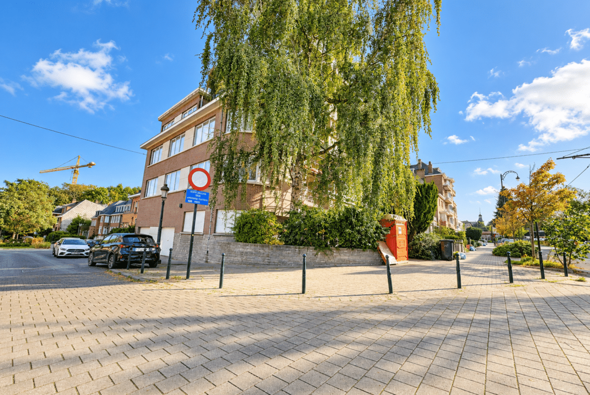 Immeuble d’appartements en briques dans quartier résidentiel arboré.