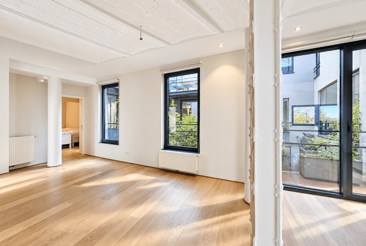 Appartement lumineux avec salon ouvert, parquet clair et accès terrasse.
