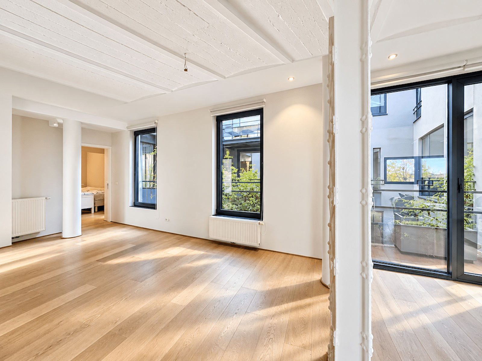 Séjour Lumineux avec Terrasse – You Real Estate Agency Appartement lumineux avec salon ouvert, parquet clair et accès terrasse.