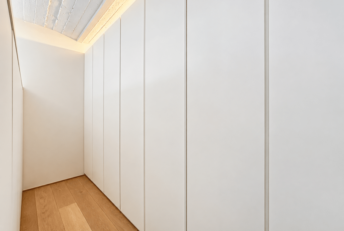 Dressing moderne avec rangements intégrés et parquet clair dans appartement contemporain.