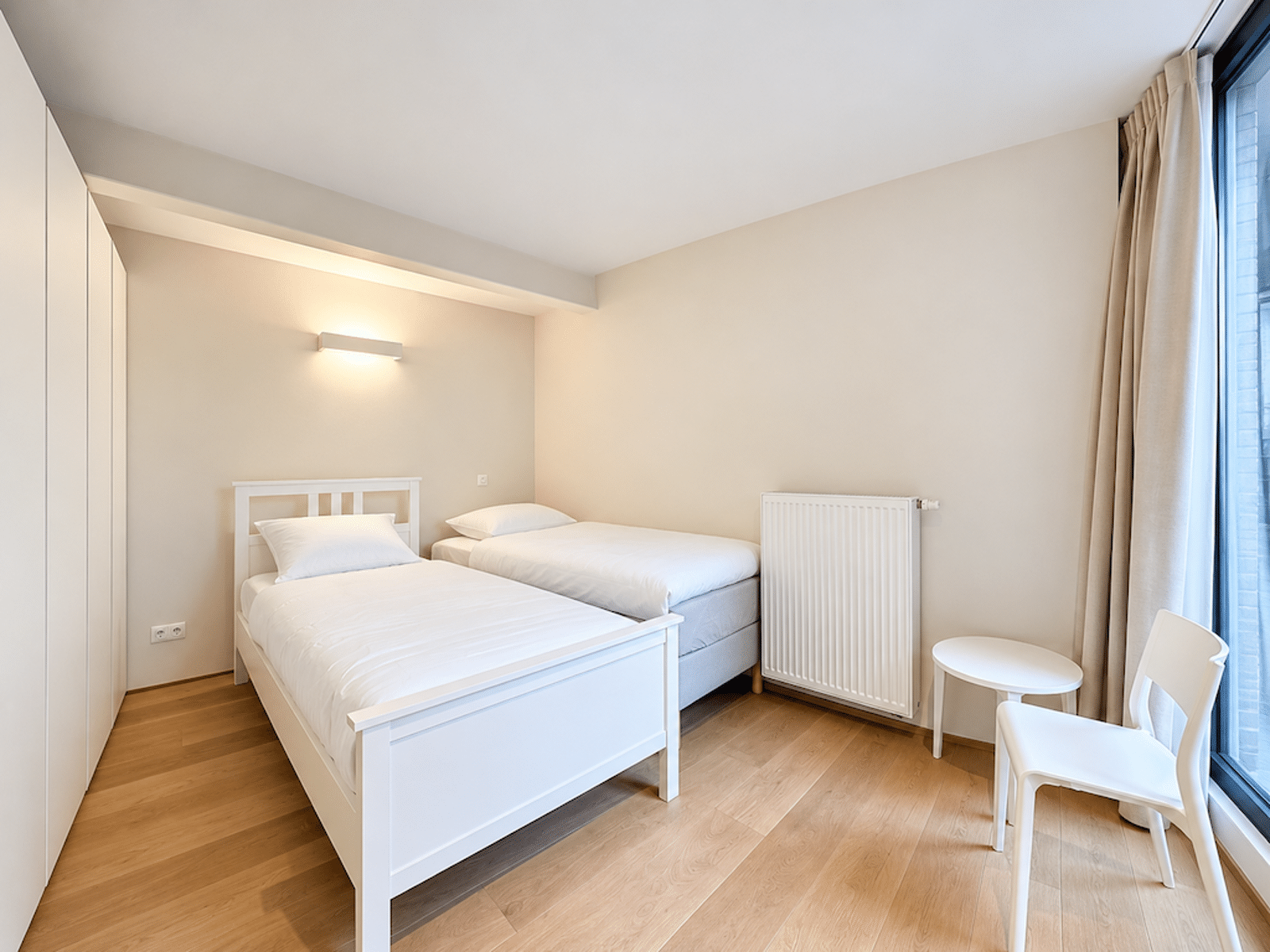 Chambre Lumineuse Avec Deux Lits – You Real Estate Agency Chambre lumineuse avec deux lits simples et rangements intégrés dans appartement moderne.