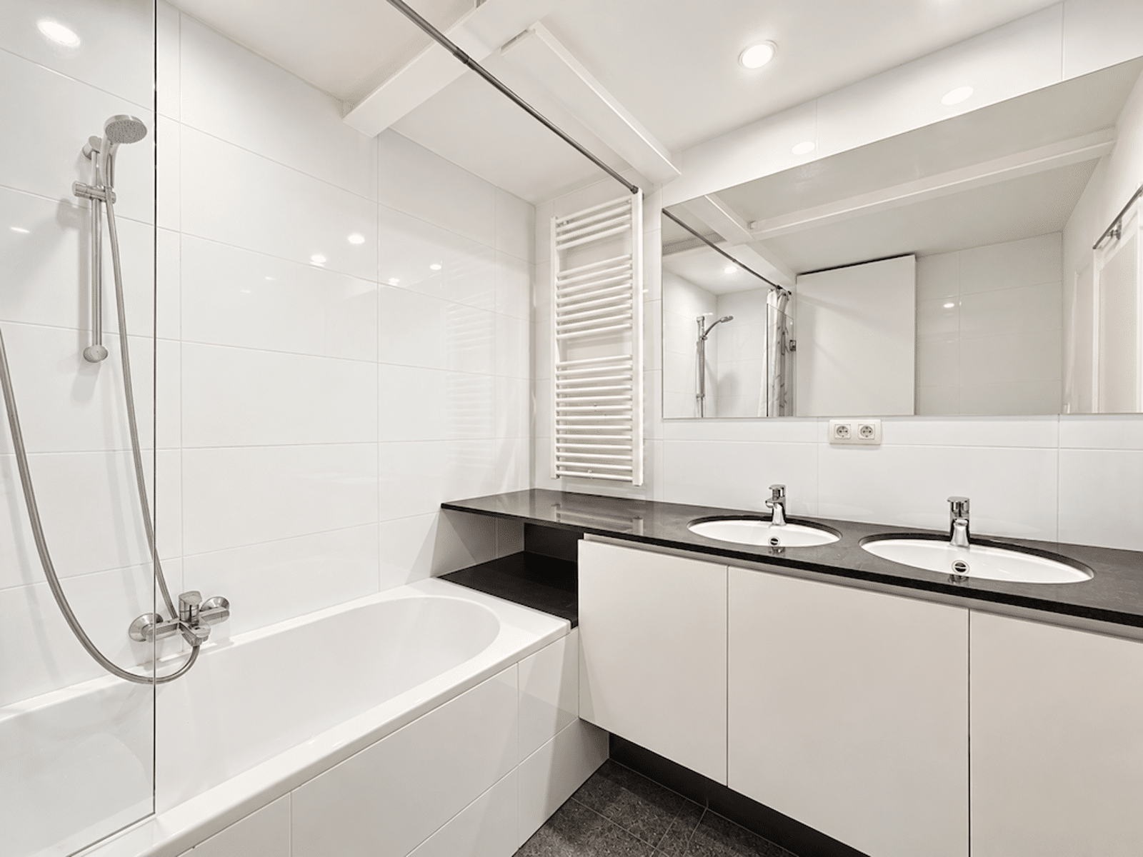 Salle de Bain Double Vasque – You Real Estate Agency Salle de bain moderne avec double vasque et baignoire dans appartement lumineux.